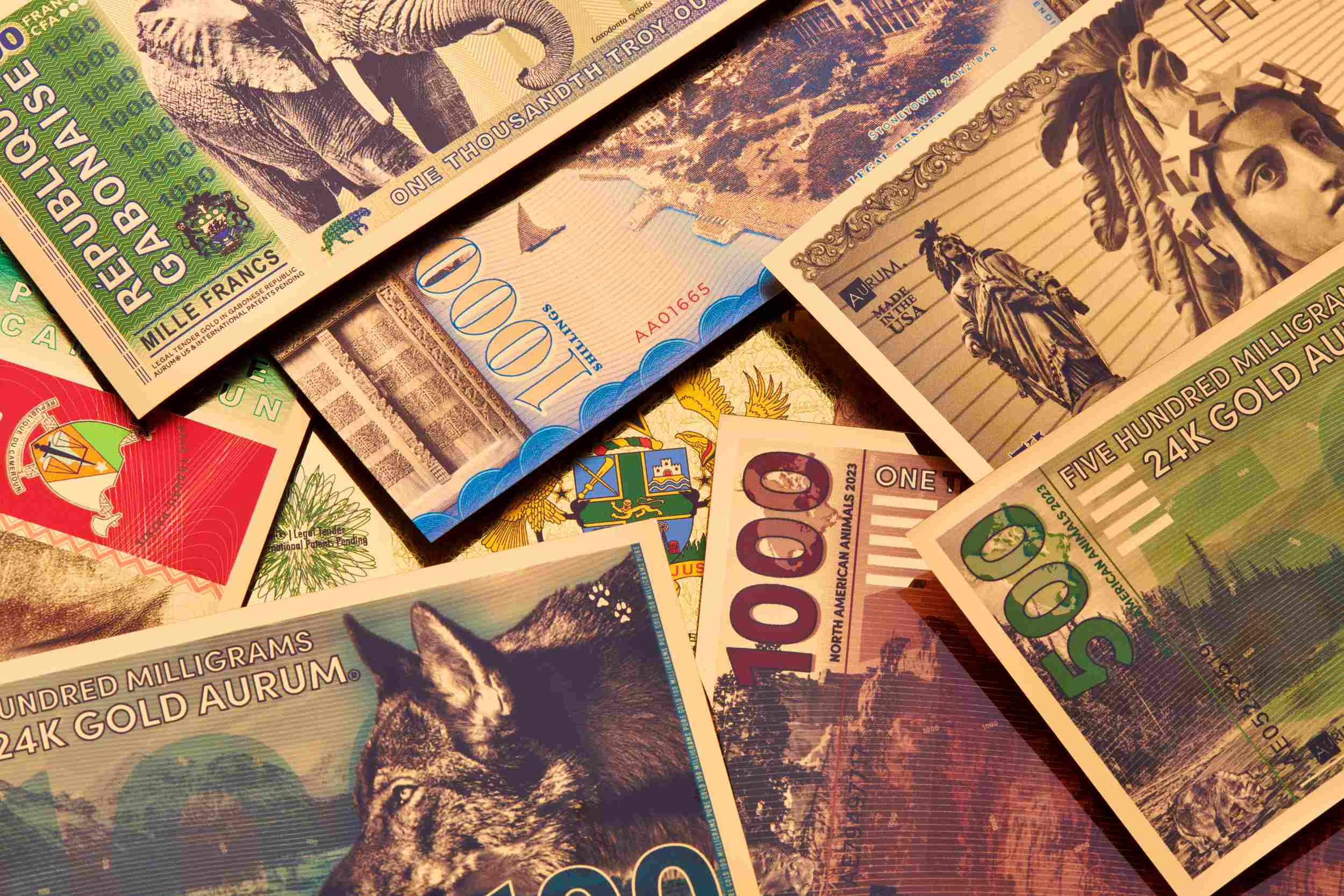 various 24k gold aurum bills inclusive of legal tender and gold backed currency spread about